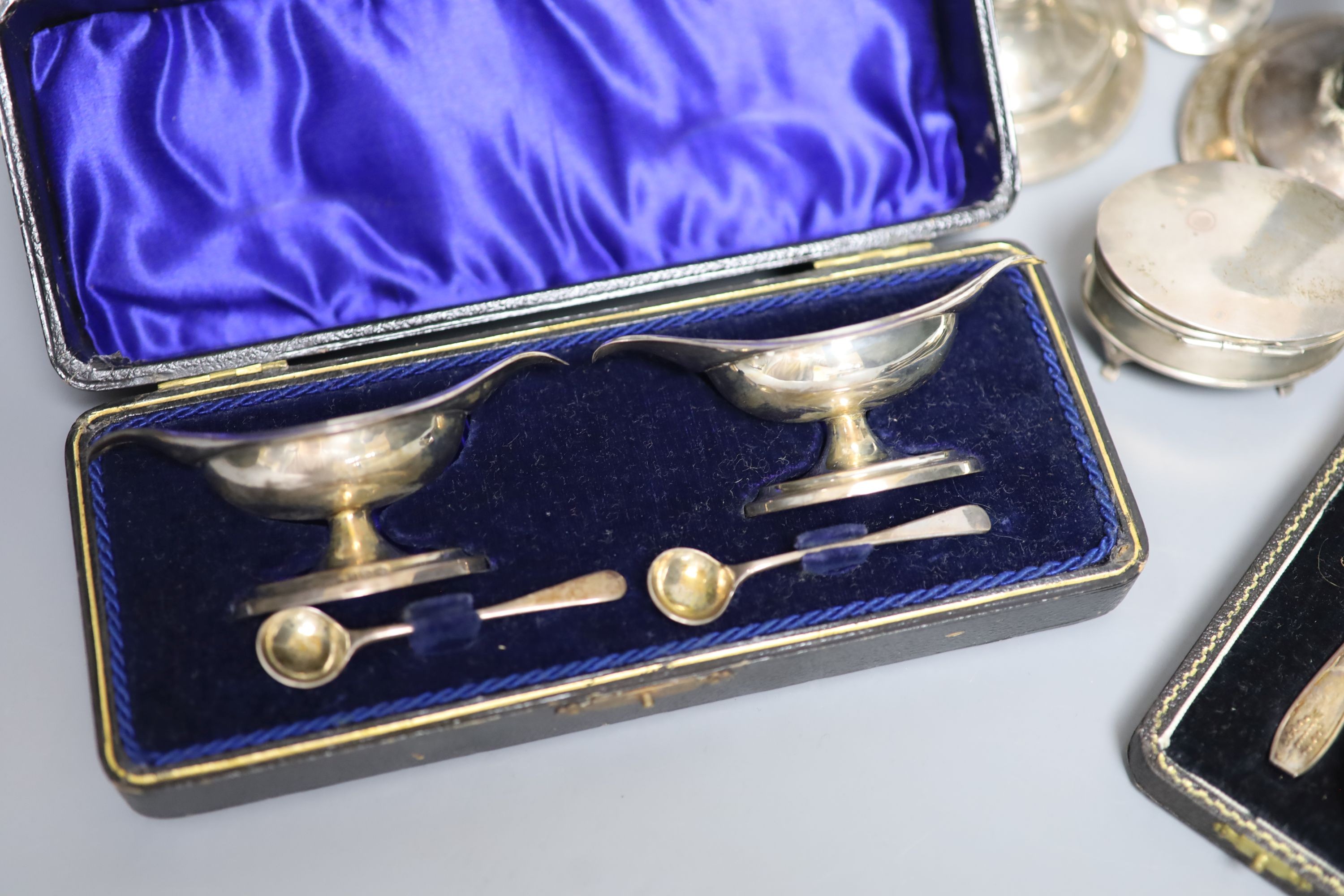 A pair of silver dwarf candlesticks(a,7.f.), 13cm, a small silver trinket box, a silver pepperette and two cased silver sets including a pair of salts and set of six teaspoons.